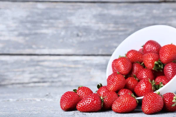 Frische Erdbeeren in Schale auf grauem Holztisch — Stockfoto