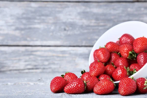 Fresas frescas en tazón sobre mesa de madera gris — Foto de Stock