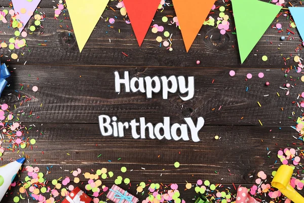 Texto Feliz Aniversário com decorações de festa na mesa de madeira — Fotografia de Stock