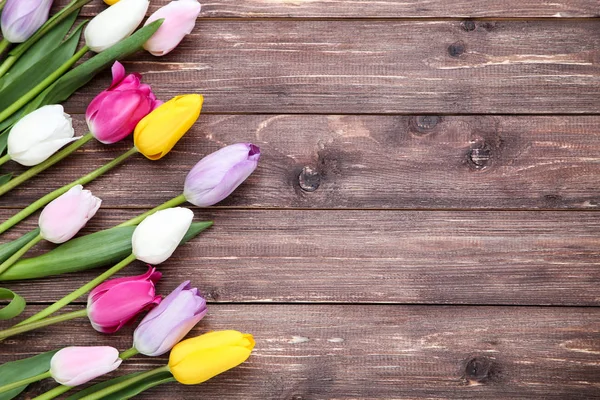 Bouquet of tulip flowers on brown wooden table — Stock Photo, Image