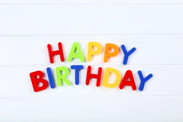 Texto Feliz cumpleaños con letras de plástico sobre mesa de madera blanca —  Fotos de Stock