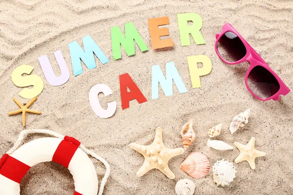 Paper text Summer camp with seashells, lifebuoy and sunglasses o — Stock Photo, Image