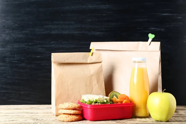 School lunch with paper bags on blackboard background