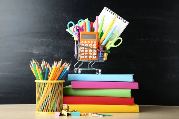 Schulbedarf mit Büchern auf Tafel-Hintergrund — Stockfoto