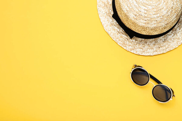 Fashion hat with sunglasses on yellow background