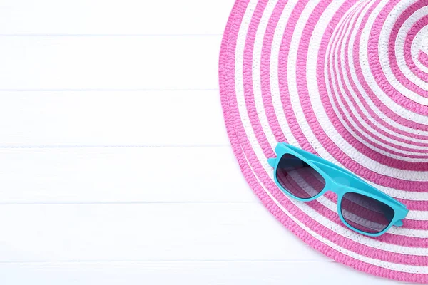 Καπέλο παραλίας με γυαλιά ηλίου σε λευκό ξύλινο τραπέζι — Φωτογραφία Αρχείου
