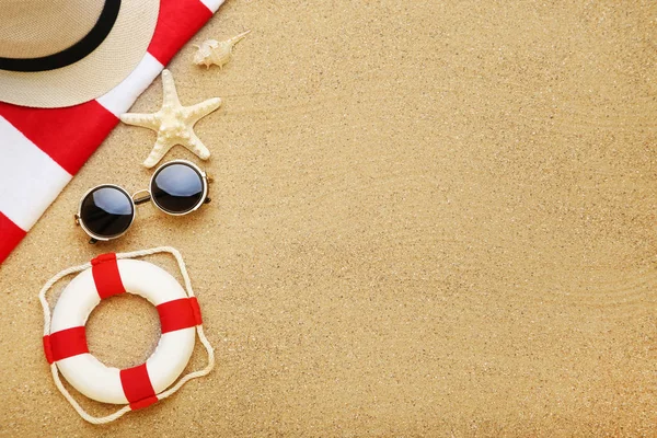Gafas de sol con conchas marinas y boya salvavidas en arena de playa — Foto de Stock