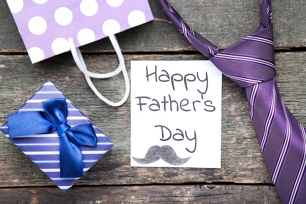 Text Happy Fathers Day with gift box, shopping bag and necktie o — Stock Photo, Image