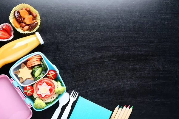 School lunch box with sandwich and vegetables on blackboard back — Stock Photo, Image