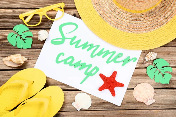 Text Summer camp with seashells, glasses, hat and flip flop on b — Stock Photo, Image