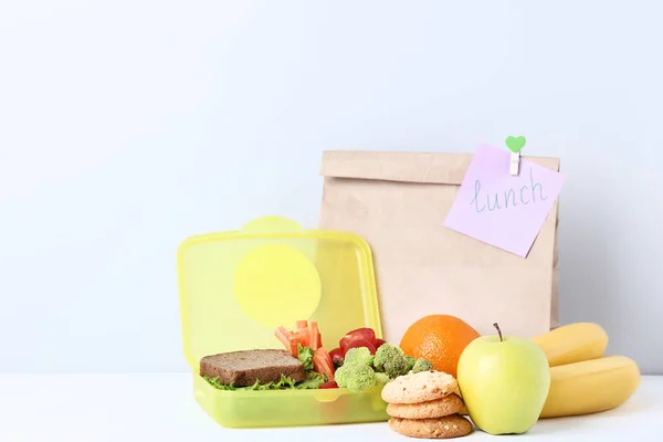 Schulessen mit Papiertüte auf grauem Hintergrund — Stockfoto