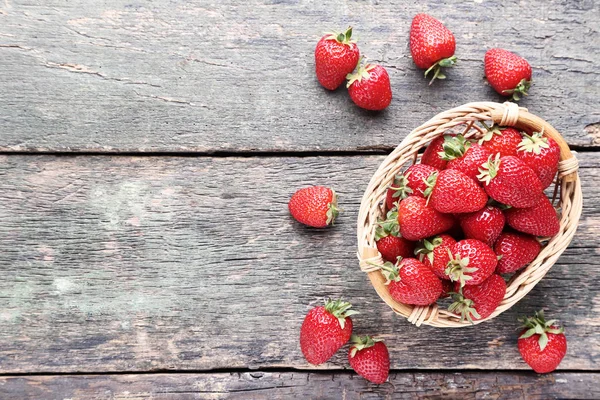 Frische Erdbeeren im Korb auf grauem Holztisch — Stockfoto