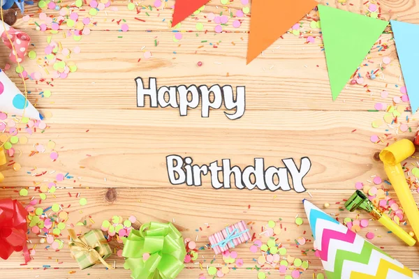 Text Happy Birthday with party decorations on wooden table — Stock Photo, Image