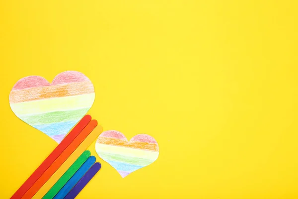 Regenbogenpapier Herz mit bunten Bleistiften auf gelbem Hintergrund — Stockfoto