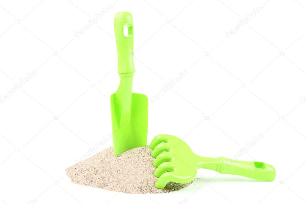 Plastic beach toys with sand isolated on white background