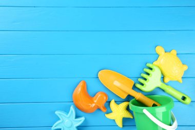 Mavi ahşap masa üzerinde plastik plaj oyuncakları