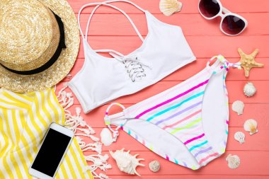 Ahşap masa üzerinde deniz kabukları ile moda mayo ve giyim