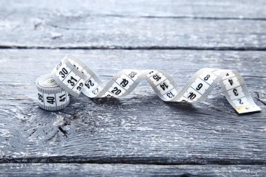 Gri ahşap masada beyaz mezura.