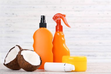 Beyaz arka planda hindistan cevizi ile güneş kremi şişeleri