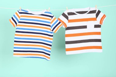 Mavi arka planda asılı bebek kıyafetleri