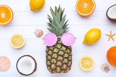 Beyaz ahşap ta güneş gözlüğü ve deniz kabukları ile Taze ananas