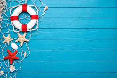 Mavi ahşap masa üzerinde lifebuoy ile deniz kabukları
