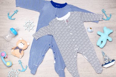 Yerde oyuncaklar, şişe ve deniz dekoru ile bebek giysileri