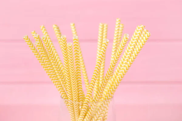 Yellow paper straws on pink background