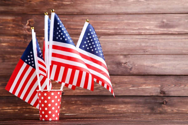 Banderas americanas en taza de papel sobre mesa de madera marrón — Foto de Stock
