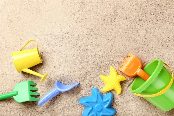 Brinquedos de plástico coloridos na areia da praia — Fotografia de Stock