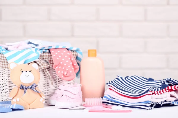 Folded clothes with soft bear toy and baby supplies