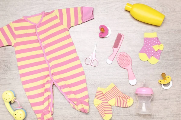 Pakaian dengan perlengkapan bayi di lantai — Stok Foto