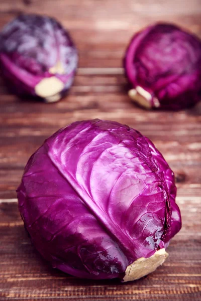 Fresh red cabbages on brown wooden table — Stock Photo, Image