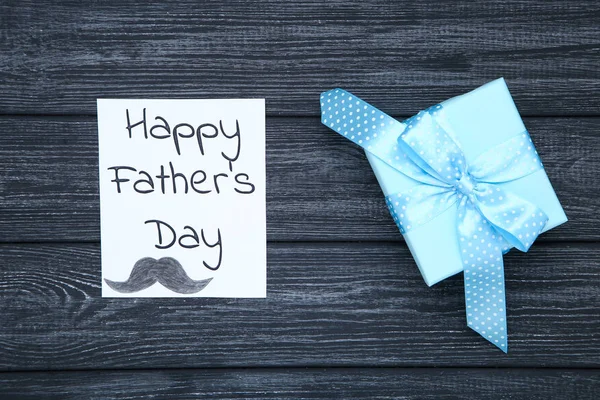 Text Happy Fathers Day with gift box on black wooden table — Stock Photo, Image