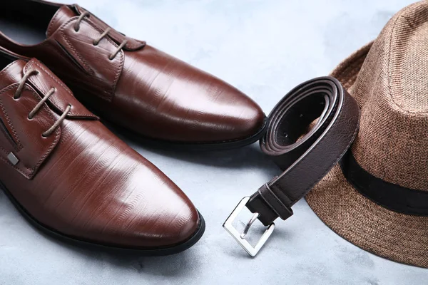 Zapatos de piel masculina con cinturón y sombrero sobre fondo gris —  Fotos de Stock