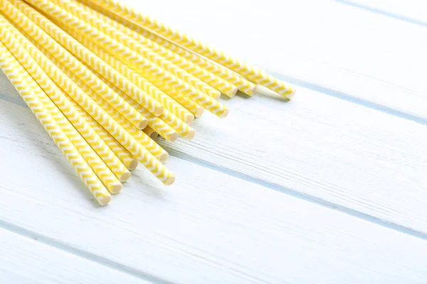 Yellow paper straws on wooden table — Stock Photo, Image
