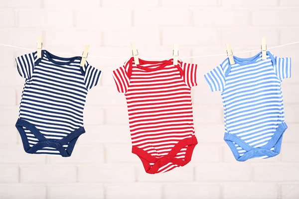 Bayi bodysuits tergantung di dinding latar belakang — Stok Foto