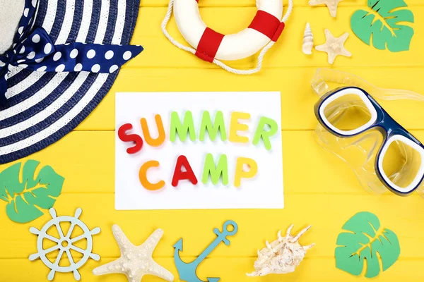 Text Summer camp with seashells, hat and diving mask on yellow w — Stock Photo, Image