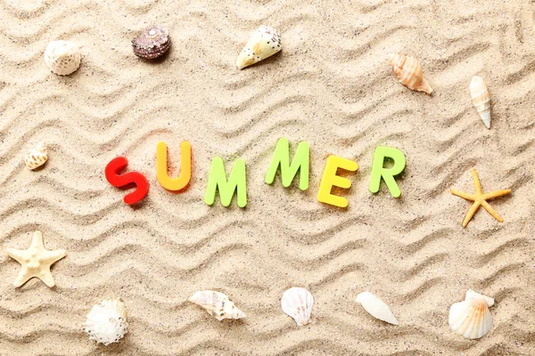 Palabra de verano con conchas marinas en arena de playa —  Fotos de Stock