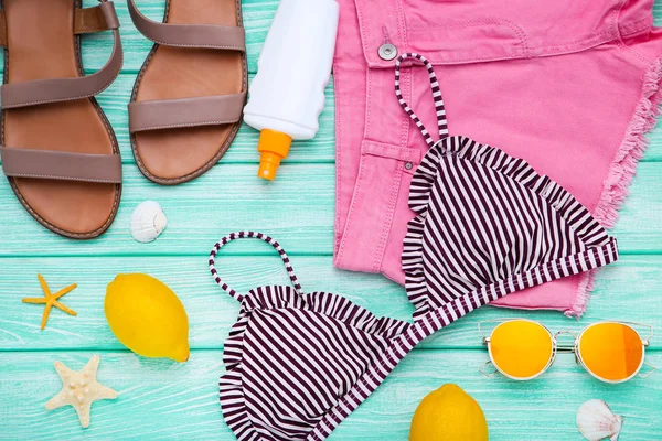Pakaian fashion dengan kerang laut dan lemon di atas meja kayu — Stok Foto