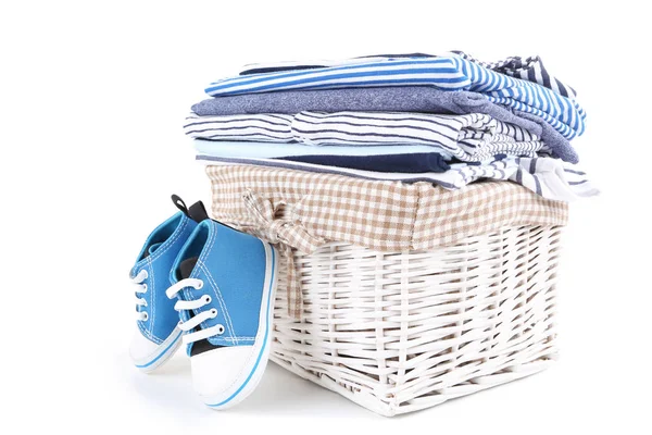 Different folded baby clothes with pair of shoes isolated on whi — Stock Photo, Image