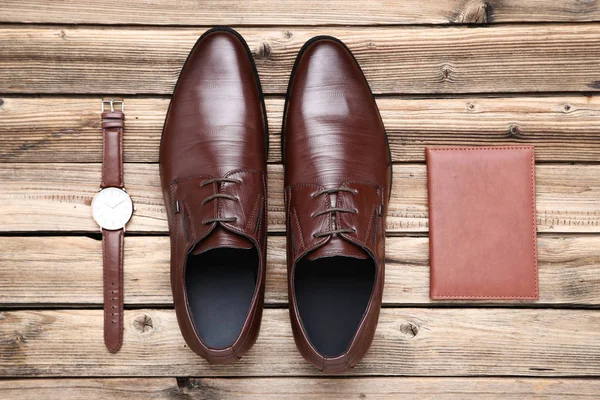 Male leather shoes with passport and wrist watch on brown wooden — Stock Photo, Image