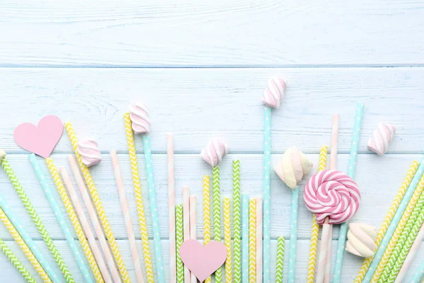 Palhas de papel coloridas com marshmallows na mesa de madeira — Fotografia de Stock