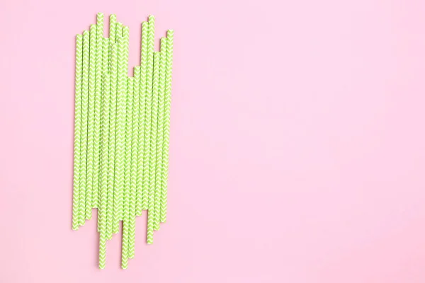 Зеленая бумага соломинки на розовом фоне — стоковое фото