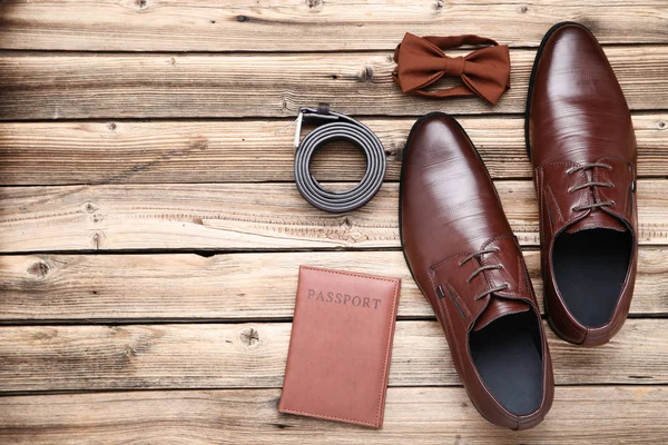 Male leather shoes with passport and accessories on brown wooden — Stock Photo, Image