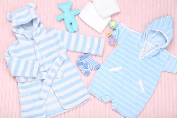 Bayi pakaian dengan mainan dan popok di latar belakang merah muda — Stok Foto