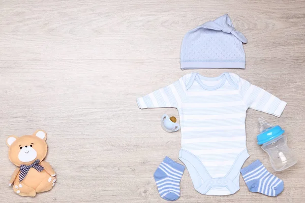 Bayi pakaian dengan mainan beruang lembut, soother dan botol di lantai — Stok Foto