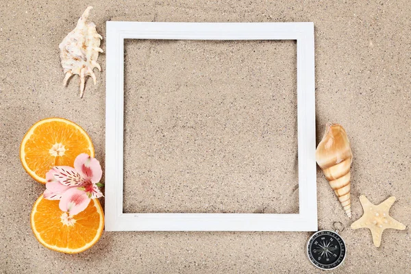 Wooden blank frame with seashells and orange fruits on beach san — ストック写真