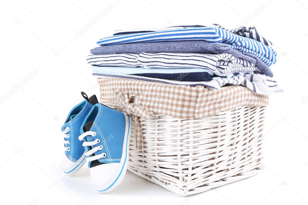 Different folded baby clothes with pair of shoes isolated on whi