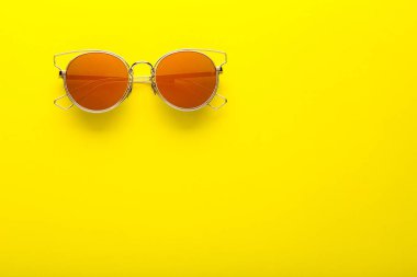 Sarı arka planda modern güneş gözlüğü